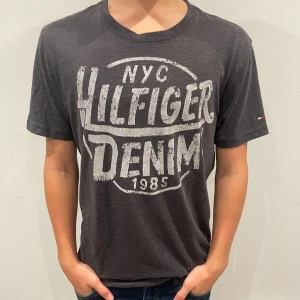 Snygg Tommy hilfigier tisha  - Säljer denna snygga tisha med ett snyggt tryck. Som passar bra med trenden laidback. Bra skick och är ifrån märket Tommy hilfigier.  Tveka inte med att höra av er!