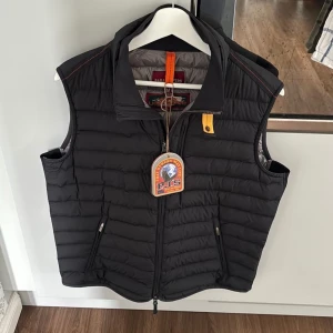Parajumpers väst M - En svart väst från Parajumpers i storlek M. Västen är i gott skick och har endast använts ett fåtal gånger. Allt original som tags och extra knappar ingår, däremot avklippt. Den är äkta och nypris är omkring 4000kr