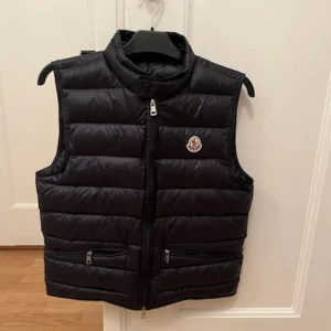 Moncler Gui väst - Tja! Säljer min äkta Moncler väst då jag har växt ur den. Västen är i 9,5/10 skick och finns inga som helst tecken på användning. Tveka inte på att höra av er om ni har frågor! Är öppen för byten och annat!