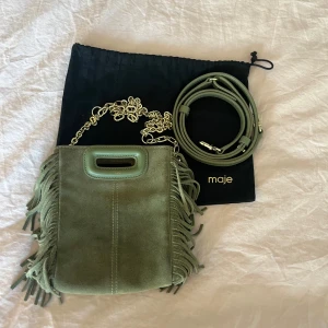 Maje väska - Säljer min super söta majeväska i olivgrön! Den är köpt här på Plick för 2200 men är i super skick. Både kedja,bandet och dustbagen ingår vid köp. Hör av er vid intresse eller om ni har några frågor💗