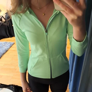 Neongrön träningskoffta - Neongrön träningskoffta, knappt använd och säljer för att den är för liten. Perfekt till att träna eller ha innan och efter träningen! Väldigt skönt material. 