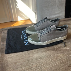 Lanvin skor - Säljer ett par stilrena grå sneakers från Lanvin. Skorna har en snygg kombination av mocka och en glansig tå i olivgrön färg. Skorna är i princip helt nya, knappt använda! Säljer dessa för 2799 men pris kan diskuteras! Skriv vid frågor😁