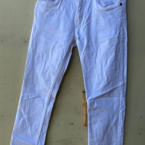 Vita byxor från Holly & White - Säljer ett par vita byxor från Holly & White by Lindex. De är i en klassisk stil med raka ben och har både fram- och bakfickor. Perfekta för en stilren look!