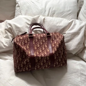 Dior väska - Säljer denna fantastiska Dior väskan i röd unik färg. Självklart äkta! Fint vintage skick, finns inga hål, fåtal fläckar, och skulle säga att den är i vintage skick. Denna modell säljs för upp emot 10-12.000kr på andra vintage sidor. Skriv för fler bilder 💘💘💘 mått: B-30 x 24 x 16 cm