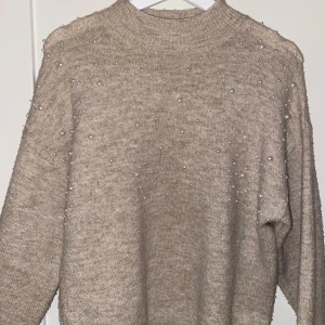 Beige stickad tröja från Zara - Säljer en superfin beige stickad tröja från Zara i storlek 164. Tröjan är dekorerad med små pärlor över hela framsidan vilket ger den en elegant touch. Perfekt för både vardag och festliga tillfällen. Den har långa ärmar och en bekväm passform. Passar perfekt till höst och vinter! Pris kan diskuteras