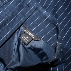 Mörkblå randig kjol från Monki - Säljer en snygg mörkblå kjol från Monki i storlek 36. Kjolen har ett klassiskt randigt mönster och är perfekt för både vardag och fest. Den är i mycket bra skick och har en stilren design som passar till det mesta!