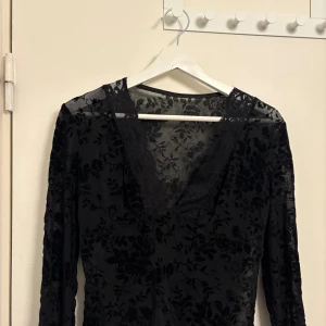 Svart blommig spetsblus - Snygg svart blus med blommigt mönster i spets. Aldrig använd 