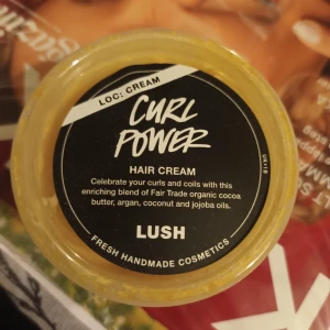 Curl Power Hair Cream från Lush - Curl Power Hair Cream från Lush är en kräm för att definiera och vårda lockar. Den innehåller Fair Trade ekologiskt kakaosmör, argan-, kokos- och jojobaoljor för att ge näring och glans. Perfekt för att fira och framhäva dina naturliga lockar och spiraler.