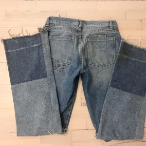 Zara jeans - Coola jeans från Zara med en patchwork-design. Low/midwaist och lite baggy i modellen. Har ett hål på knät som adderar extra detalj!