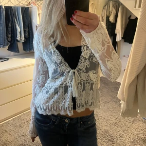 Spetsblus med knytning - Säljer en superfin beige genomskinlig spetsblus med knytning framtill. Blusen har långa ärmar och ett vackert broderat mönster med en fjäril på ryggen. Står ingen storlek, men jag skulle säga att den är en s. 💕💕