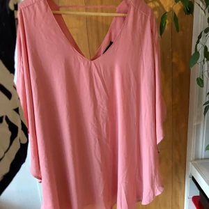 Rosa blus med v-ringning - Säljer en söt rosa blus med v-ringning. Den har en lös passform och är perfekt för vår och sommar. Blusen är i mycket bra skick och passar både till vardags och fest.