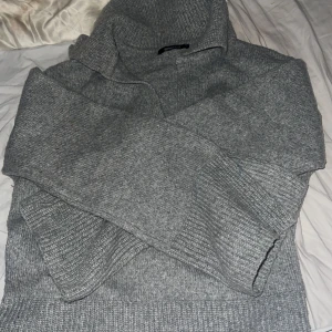 Grå stickad tröja från Gina Tricot - Mysig grå stickad tröja från Gina Tricot i storlek XS men passar också S. Perfekt för kyliga dagar med sin höga krage och långa ärmar. Tröjan har en klassisk och stilren design som passar till det mesta. Ett måste i garderoben för höst och vinter!
