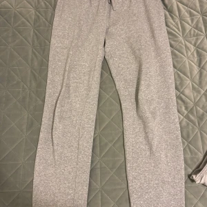 Grå mjukisbyxor från Andy by Frank Dandy - Säljer ett par superbekväma grå mjukisbyxor från Andy by Frank Dandy i storlek L. De har en elastisk midja med snörning för perfekt passform. Perfekta för mysiga dagar hemma eller en avslappnad dag ute. Materialet är mjukt och skönt mot huden.