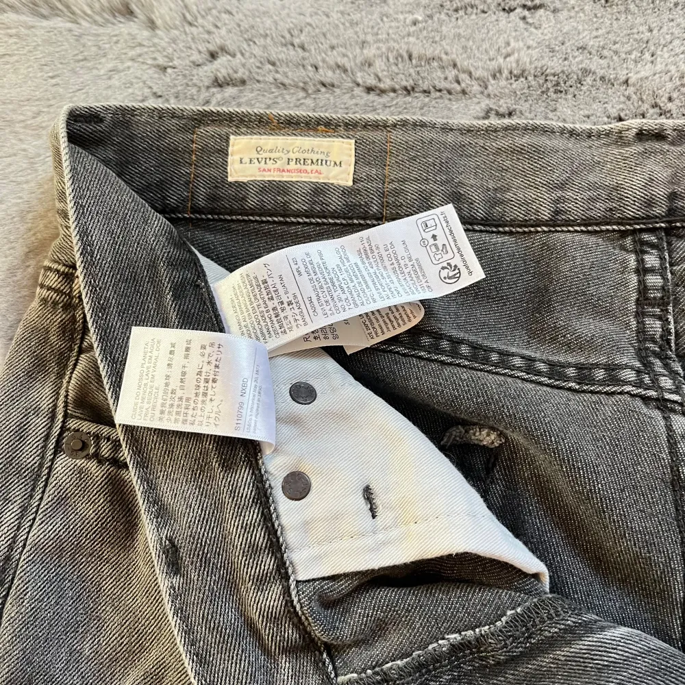 Säljer ett par grå Levis Premium jeans i bra skick. De har en snygg, sliten look med fransiga benslut och klassisk femficksdesign. Perfekta för en avslappnad stil. Passar både till vardags och fest!  Nästan oanvända! Ny pris runt 1250kr🤩. Jeans & Byxor.