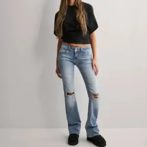 Säljer ett par ljusblå jeans i bootcut-stil med snygga slitningar på knäna. Dom är low waist och är från Nelly. Bara använda två gånger!!❤️❤️ nypris är 699. 