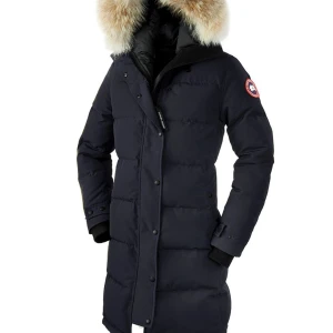  Canada Goose shelburne - Säljer en svart dunjacka från Canada Goose med en lyxig pälsdetalj på huvan. Jackan är perfekt för kalla vinterdagar och har en lång passform med dragkedja och knappar. Den är i nyskick  och redo för nya äventyr. Tags och allt finns kvar . Perfekt för vinterns alla utmaningar! ❄️