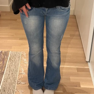 Blå bootcut jeans - Säljer ett par snygga blå bootcut jeans i bra skick. Lågmidjade från Fishbone. Storlek 26. (Jag är 163) 