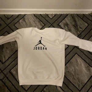 Vit Jordan sweatshirt - Säljer en snygg vit Jordan sweatshirt med det klassiska Jumpman-logotypen på både fram- och baksidan. Tröjan har långa ärmar och är perfekt för en casual look. Den är i bra skick och passar perfekt för höst och vår.storlek S priset kan diskuteras vid snabb äffar