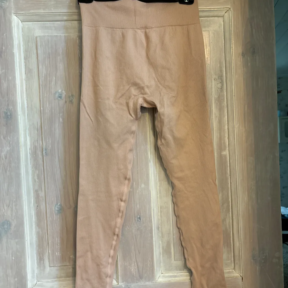 Ljusrosa/beige träningsbyxor. Tyget är lite ribbat. Färgen är något mer rosa i verkligheten. Fint skick. Fler bilder vid förfrågan!. Sportswear.