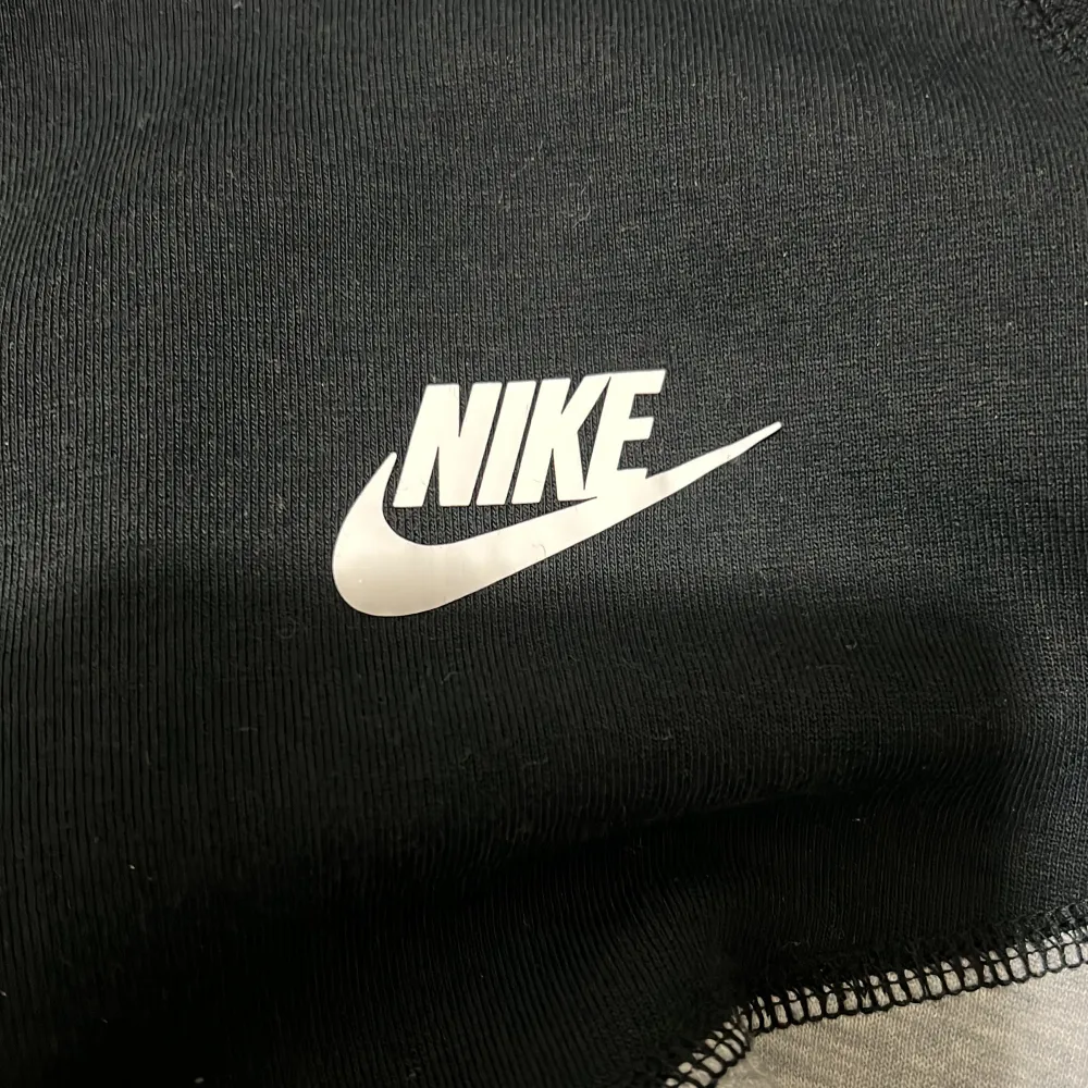 Säljer en snygg och bekväm grå och svart hoodie från Nike. Den har en dragkedja framtill och två praktiska fickor med dragkedjor. Perfekt för både träning och vardag. Hoodien är i nyskick och har en klassisk Nike-logga på bröstet.. Jackor.