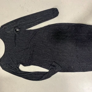 Svart glittrig klänning från BIK BOK - Säljer en svart klänning från BIK BOK i storlek S. Den är glittrig med randigt mönster och har långa ärmar ✨