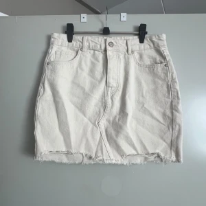 Beige jeanskjol från Only - Säljer en superfin beige jeanskjol från Only. Den har en klassisk femficksdesign och en rå kant nertill som ger en cool och avslappnad look. Perfekt för både vardag och fest! 🥰