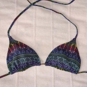 Flerfärgad bikinitopp - trekantsbikini - storlek 38 (36) - Bikinitopp i storlek 38 (skulle säga att den också passar storlek 36), utan inlägg. Resåret i banden är lite stelt/knöligt på vissa ställen. Kan skickas med ett frimärke (22 kr).