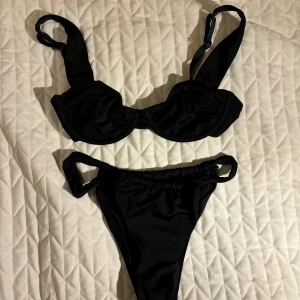 Svart bikini Na-KD - Svart bikini från Na-Kd som endast är testad och tvättad. Trosan är i storlek XS (men passar mig som har S) och toppen är i 70D men liten i storleken så mer som en C kupa skulle jag säga. 