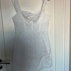 Vit klänning med broderade blommor - Vit klänning från SHEIN i strl L. Nyskick (aldrig använd, endast provad) passar perfekt som student, skolavslutning eller konfirmationsklänning.