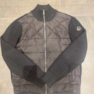 Moncler cardigan - Nu har tiden kommit för att sälja min moncler cardigan där med att jag har köpt en ny. Storleken ä 170-180. Det enda dåliga är att vid högra armhålan är det ett litet hål däremot syns den inte när du har på dig den. Den är köpt från vongreven closet.