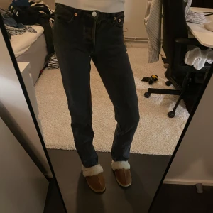 Svarta jeansbyxor - Snygga svarta jeansbyxor med en klassisk straight passform. De har en hög midja och är perfekta för en stilren look. Byxorna har knappar framtill.