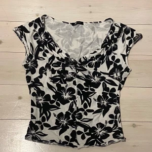 Svartvit blommig topp - Snygg svartvit v-ringad topp med blommigt mönster. Perfekt för sommarn💕