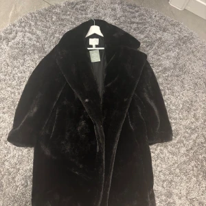 Svart pälsjacka från H&M storleken är Xs men den är stor i storleken så om du har storlek S eller M så skulle den passa perfekt. Den är helt ny och aldrig använd. - Säljer en elegant svart pälsjacka från H&M. Jackan har en klassisk design med långa ärmar och en mjuk, lyxig känsla. Perfekt för att hålla sig varm och stilren under kyliga dagar.