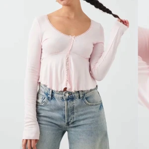 Rosa långärmad topp från Gina Tricot - Söt rosa långärmad topp från Gina Tricot med spetsdetaljer och en liten rosett framtill. Toppen har en croppad passform och rund halsringning. Perfekt för en gullig sommarlook. Använd 1 gång. Strl S💕