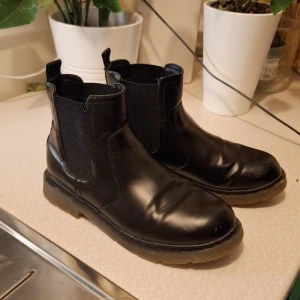 Skor/ridskor - Ett par svarta skor, själv har jag använt dem som ridskor efter som att de har en bra klack för det. Dem är fina och glansiga har ändrat lite repor som man kan se på sista bilden, reporna är på insidan vis stortån för att vara exakt. De ät använda ca ett halvår av mig. De är I storlek 39. Jag säljer dem pga att dem har blivit för små för mig. ✨️