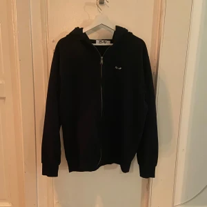 Cdg zip hoodie  - Hej, jag säljer en stilren zip hoodie från cdg. Hoodie är knappt använd och i väldigt bra skick då den inte har nå defekter eller fläckar. Hoodien är något otroligt bekväm och märket är välkänt. Nypris ligger runt 3000kr. Pris kan diskuteras, buda gärna! 