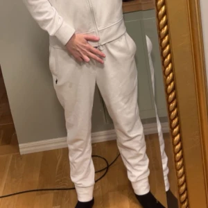 Vita byxor från Polo Ralph Lauren - Säljer ett par stilren vit byxor från Polo Ralph Lauren med det klassiska logotypen på benet. Perfekt för en avslappnad look.Byxorna har en bekväm passform.