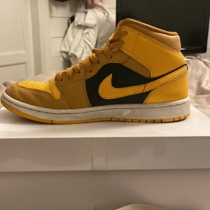 Nike Air Jordans i gult och svart - Snygga Nike Air Jordans i en iögonfallande gul och svart färgkombination. Skorna har klassisk snörning och en bekväm passform, perfekta för både stil och komfort. Skorna har creasat men den är i bra skick. 