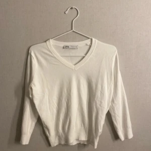 Vit v-ringad tröja från Zara - Säljer en snygg vit v-ringad tröja från Zara. Tröjan har trekvartsärmar, alltså att den är mellan en T-shirt och tröja i längden på armarna. Tröjan ska gå ungefär åvanför armbågarna! Tröjan passar även som S💗