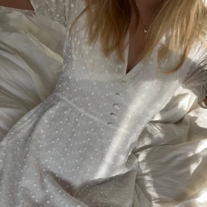 Vit klänning - Vit klänning perfekt till student eller skolavslutning🥰klänningen har blommönster och v-ringning. Resår baktill som gör att den sitter perfekt längst kroppen💕Använd en gång på min konfirmation men får inte användning för den. Jätte fint skick 