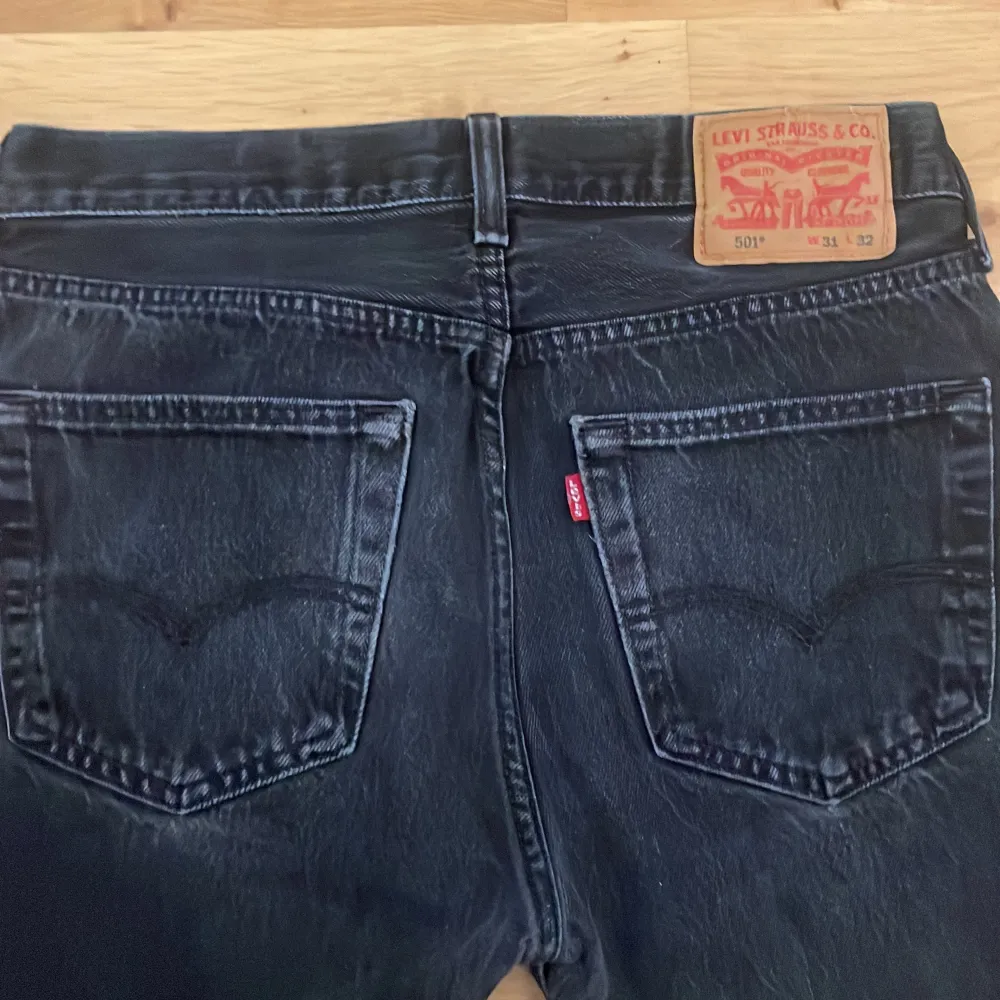 Säljer ett par klassiska svarta Levi's 501 jeans. De har en rak passform och är tillverkade i slitstarkt denim. Perfekta för en stilren look med fem fickor och knappgylf. Skick 10/10. Storlek: W31 L32.. Farkut & Housut.