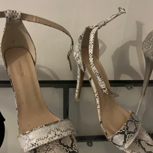 Ormskinnsmönstrade pumps med ankelrem - Snygga pumps från Steve Madden med ormskinnsmönster och ankelrem. Perfekta för att ge en trendig touch till din outfit.