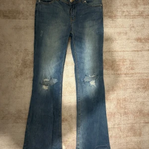 Blå bootcut jeans med slitningar - Jätte snygga jeans aldrig använda då dom tyvärr va lite för korta för mig. Köpta secondhand innan men va oanvända innan ja köpte. 