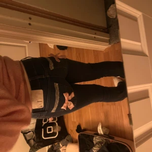 Blå jeans med rosa detaljer - Snygga blå jeans med unika rosa rosetter på bakfickorna. Jeansen har jag själv sytt om från skinny till bootcut. Har även sytt på detaljerna. Perfekta för att ge din outfit en söt och lekfull touch. 