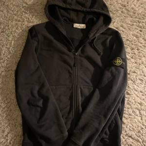 Stone island zip hoodie - Säljer en äkta Stone island zip hoodie i färgen svart och stolrek S. 8/10 skick den må se lite skrynklig på första bilden men är inte alls de. Passar även M. Mer bilder eller frågor är det bara att höra av dig!!