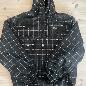 Supreme x Lacoste Regn Jacka - Storlek M i bra kondition.  Reflective lacoste logga, snygg och håller sig bra i regn. Mysigt material på insidan också