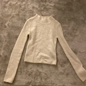 Vit ribbad tröja från H&M Divided - Säljer en superfin vit ribbad tröja från H&M Divided. Den är i storlek 3XS och har en hög krage som ger en stilren look. Perfekt för både höst och vinter, och den är långärmad vilket gör den extra mysig. ❤️
