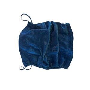 Glitter linne - Ett blått glitter linne som passar perfekt till fester, toppen är i kryssform vid ryggen. Ett litet strävare Matrieal men inget som stör en