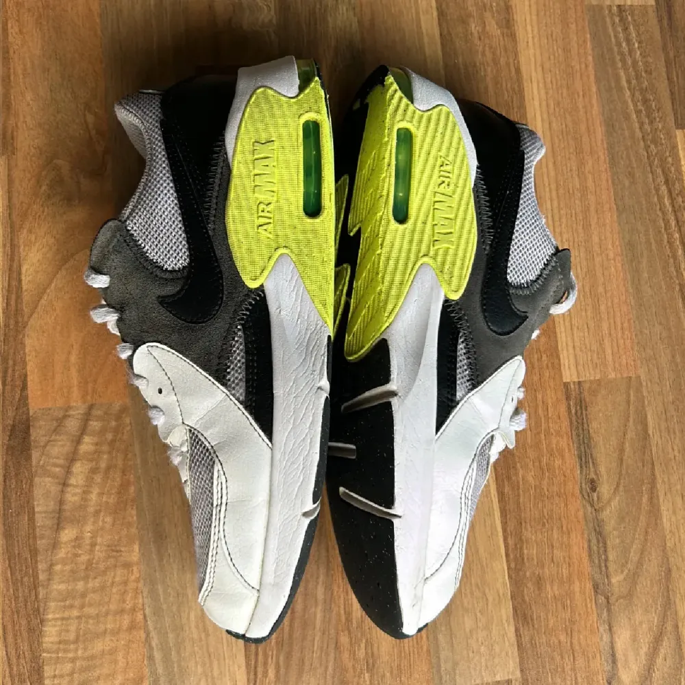 Säljer ett par Nike Air Max sneakers i grått och neongult. De har en cool design med svarta detaljer och den klassiska Air Max-sulan. Perfekta för både träning och vardagsbruk. Skorna har snörning och är i bra skick.. Skor.