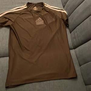 Säljer en svart t-shirt från Adidas i nyskick. Den har korta ärmar och klassiska vita ränder längs axlarna. Adidas-loggan på bröstet har en cool, med reflex på adidas loggan Passar bra till jeans!